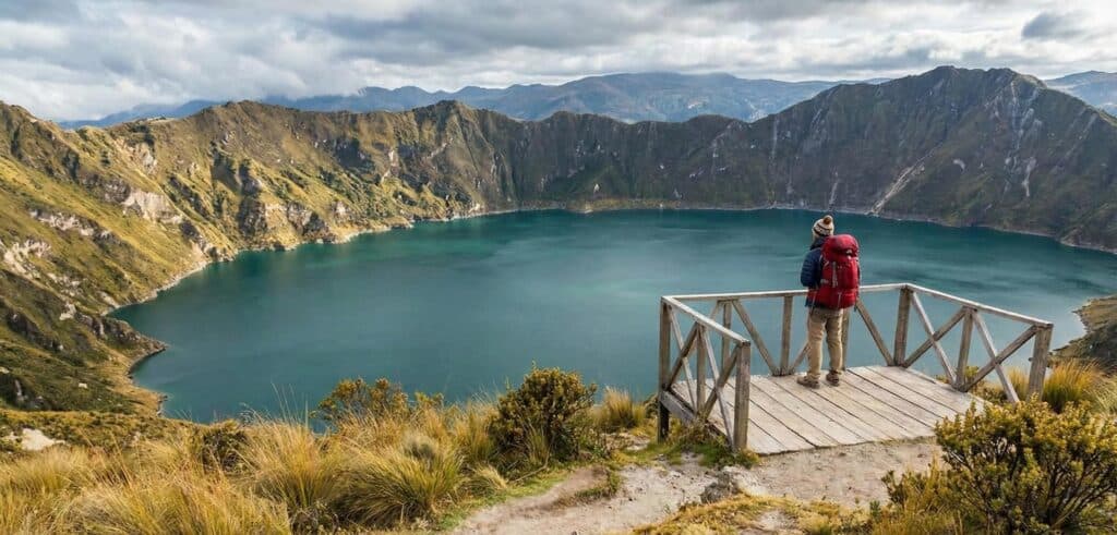 Hiker overlooking turquoise mountain lake from viewpoint
