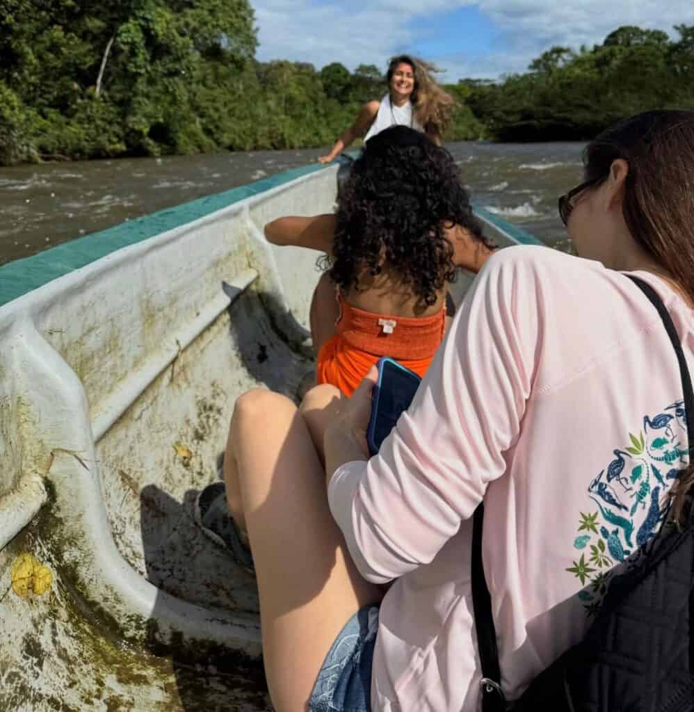 Amigos disfrutando de un paseo en barco por un río tropical.