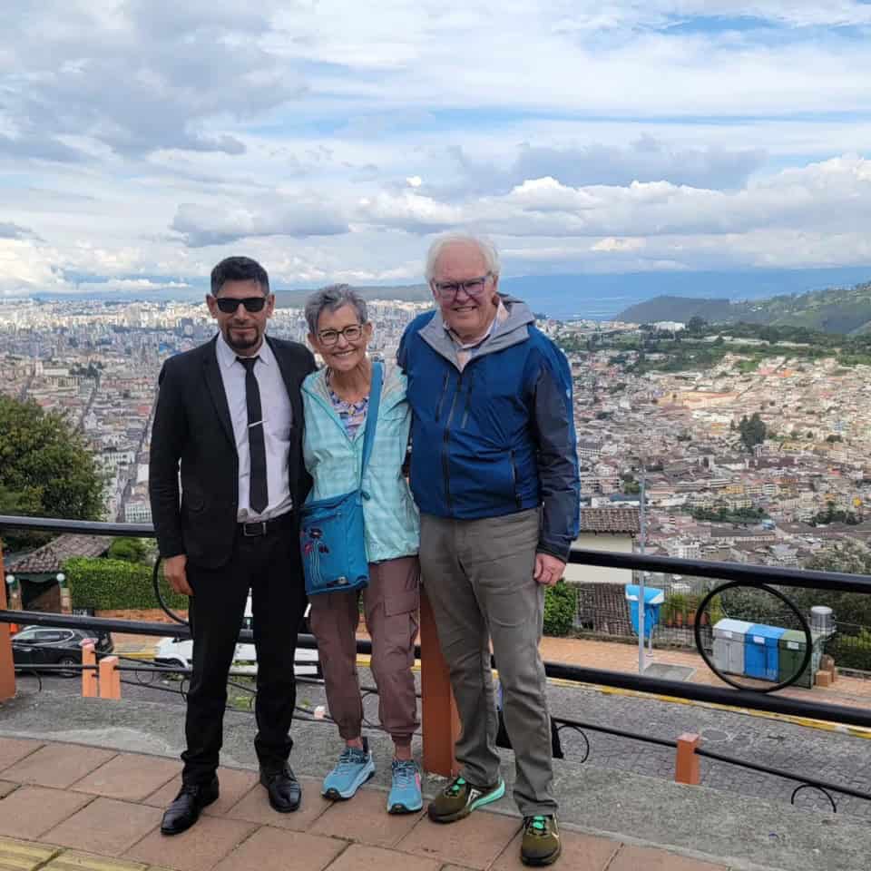 Three people smiling with city view background