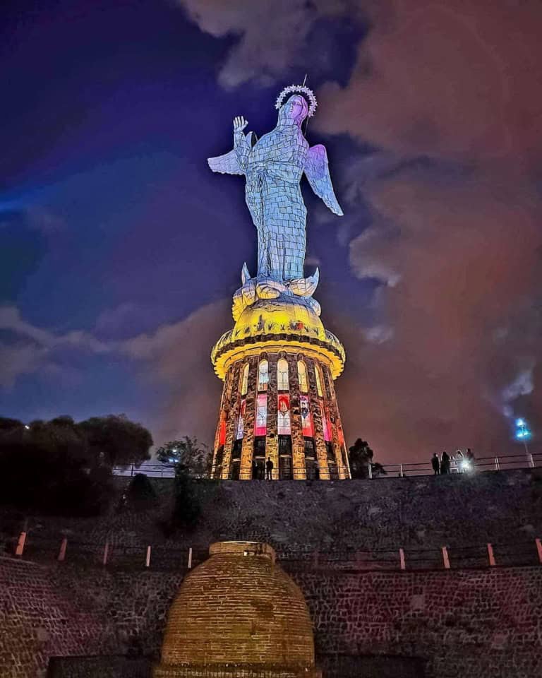 Illuminated statue on hill at night