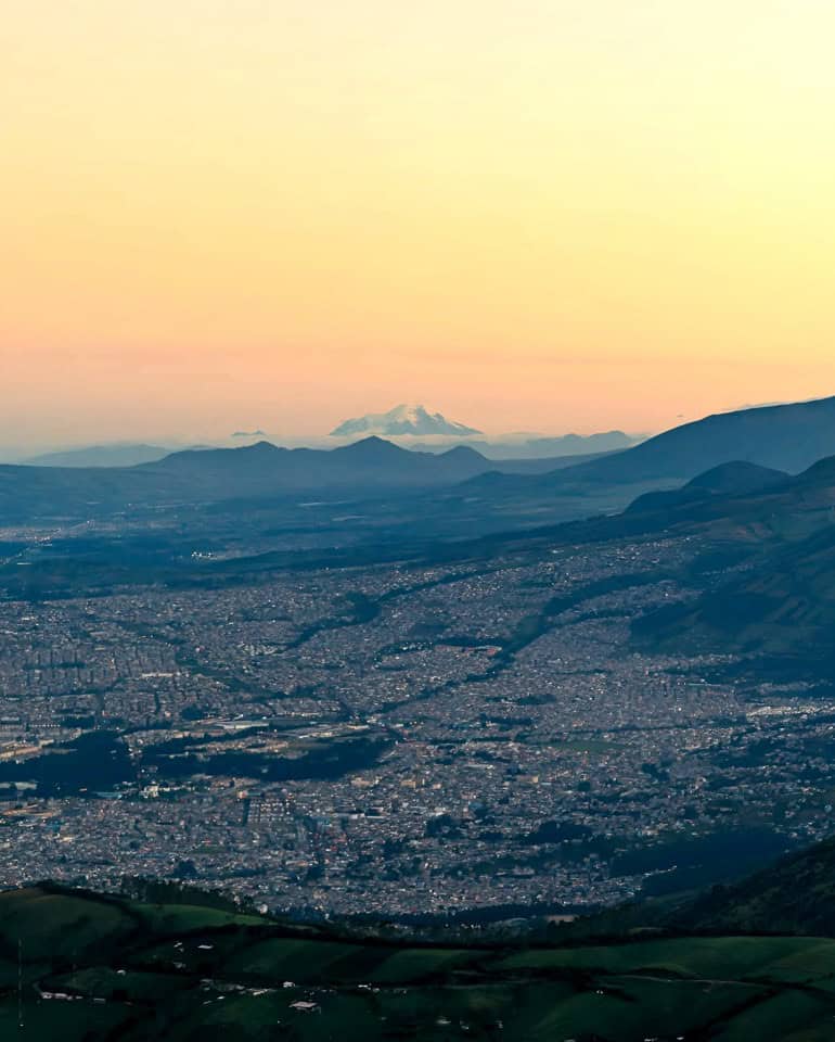 Cityscape with distant snow-capped mountain at sunrise